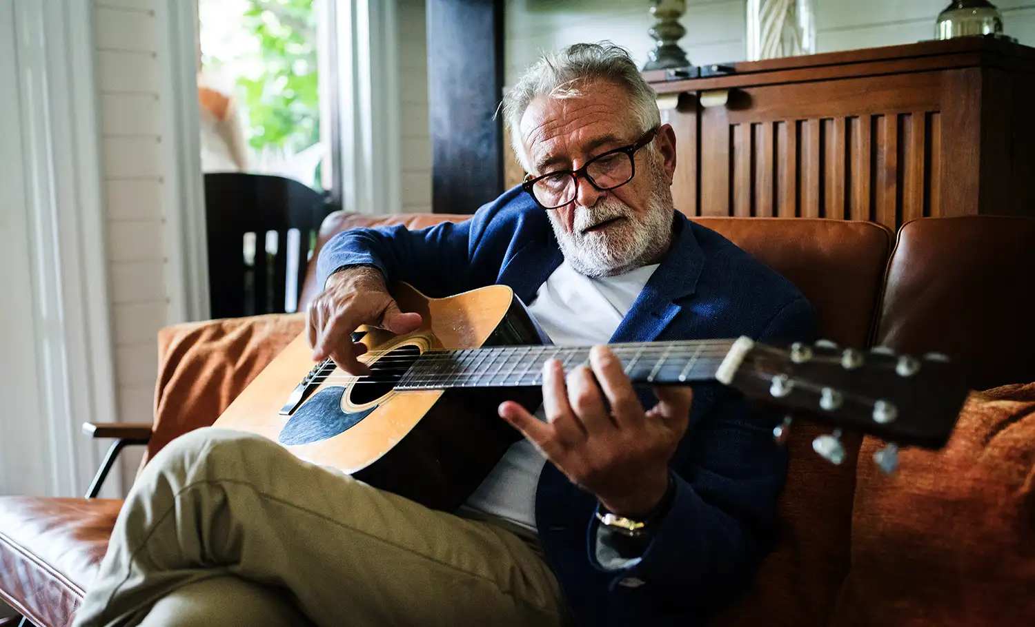 older man playing the guitar as a hobby
