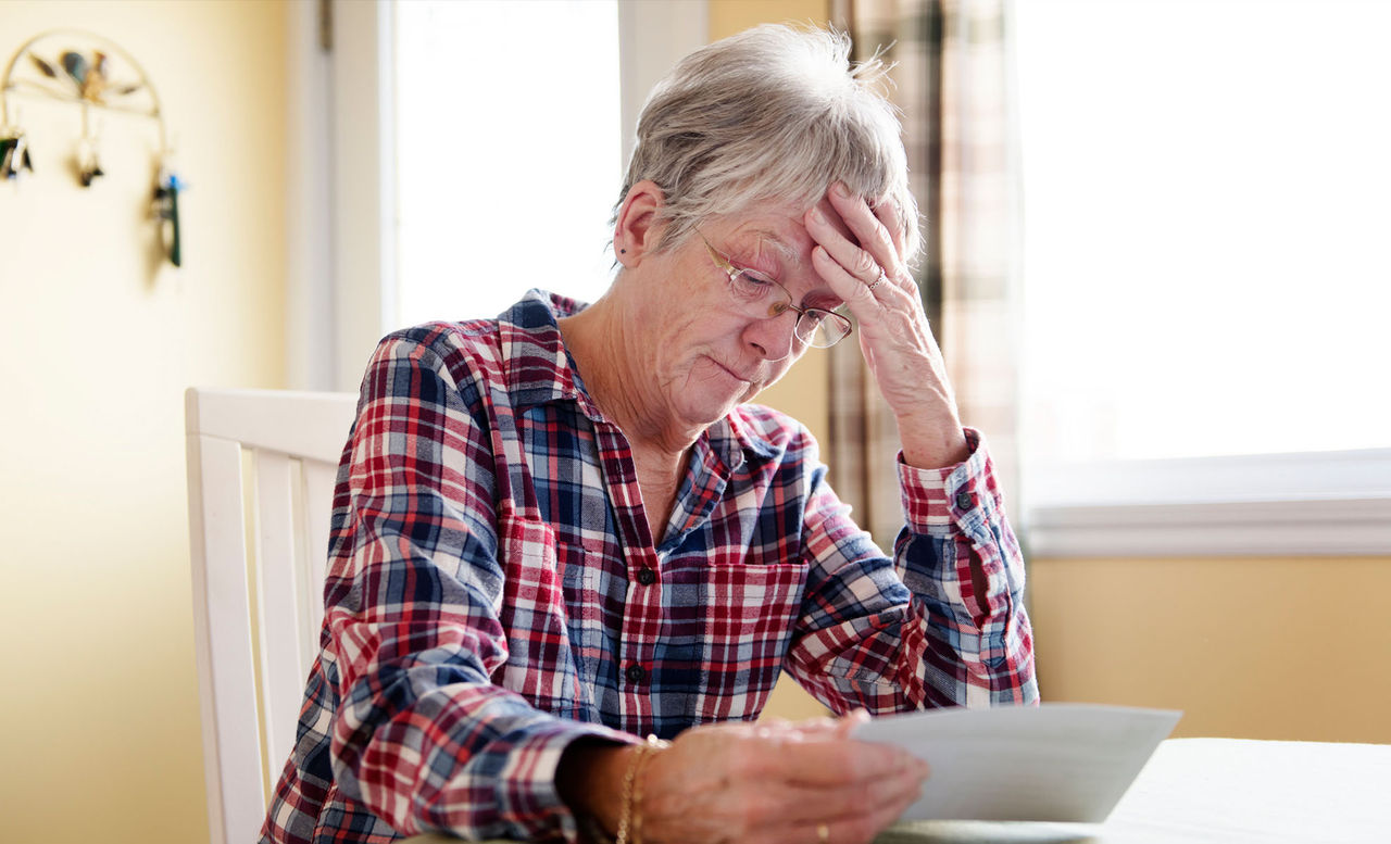 senior woman looking concerned at her medical bills