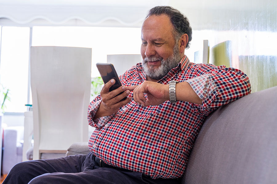 Person on the couch using the patient portal with their phone