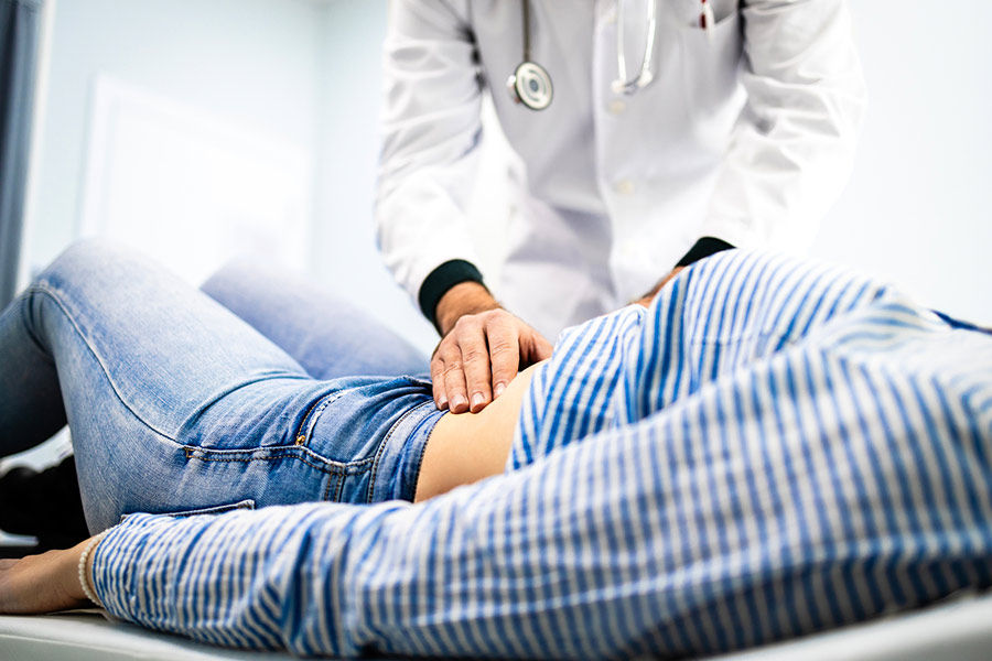 Gastroenterologist performing an abdominal examination on a patient