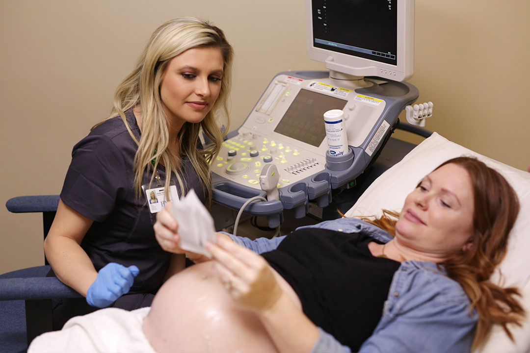 Healthcare professional performing a prenatal ultrasound on a pregnant woman