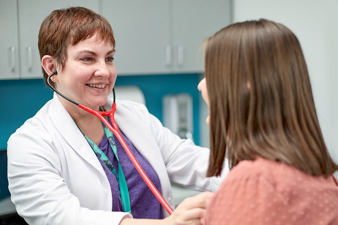 Primary care physician with patient during an exam